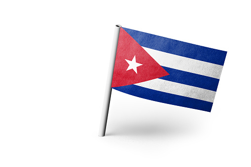 Small paper flag of Cuba pinned. Isolated on white background. Horizontal orientation. Close up photography. Copy space.