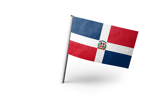 Small paper Dominican Republic flag pinned. Isolated on white background. Horizontal orientation. Close up photography. Copy space.