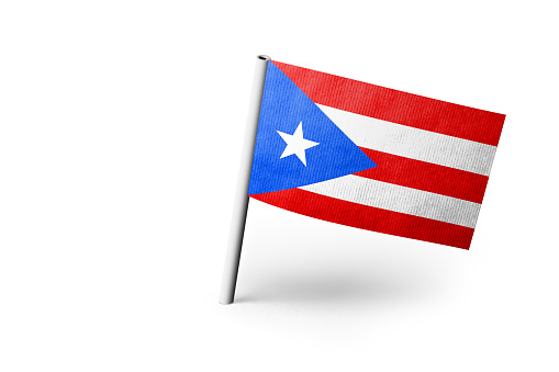 Small paper flag of Puerto Rico pinned. Isolated on white background. Horizontal orientation. Close up photography. Copy space.