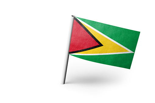 Small paper flag of Guyana pinned. Isolated on white background. Horizontal orientation. Close up photography. Copy space.