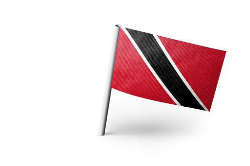 Small paper flag of Trinidad and Tobago pinned. Isolated on white background. Horizontal orientation. Close up photography. Copy space.