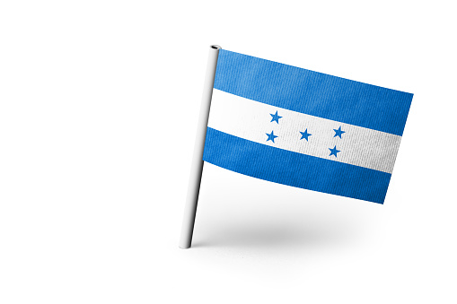 Small paper flag of Honduras pinned. Isolated on white background. Horizontal orientation. Close up photography. Copy space.