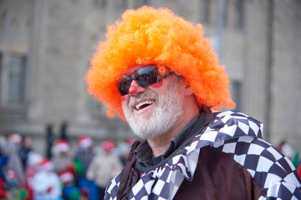 Toronto, Ontario, Canada- November 20th, 2022: A head shot of man in orange clown hair during Toronto’s annual Santa Claus Parade.