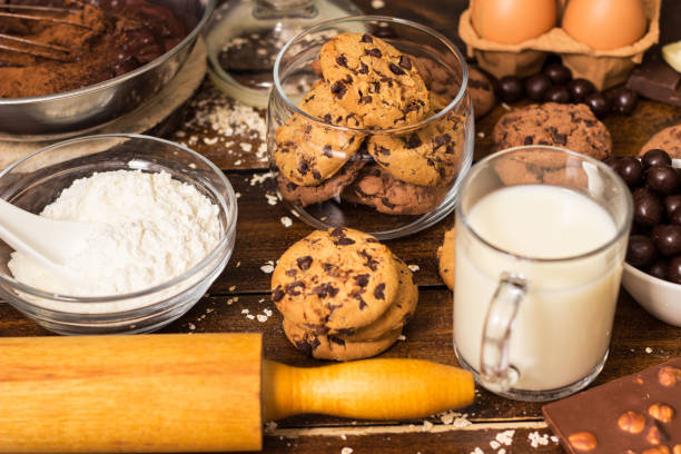 Ingredients for preparing and baking cookies. Ingredients includes are flour, eggs, chocolates, chocolate chips, sugar,  milk,  butter, and equipment