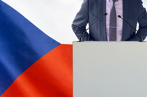 Tribune with microphone and businessman in suit on Czech Republic flag background. Politician at the podium with microphones background Czech Republic flag