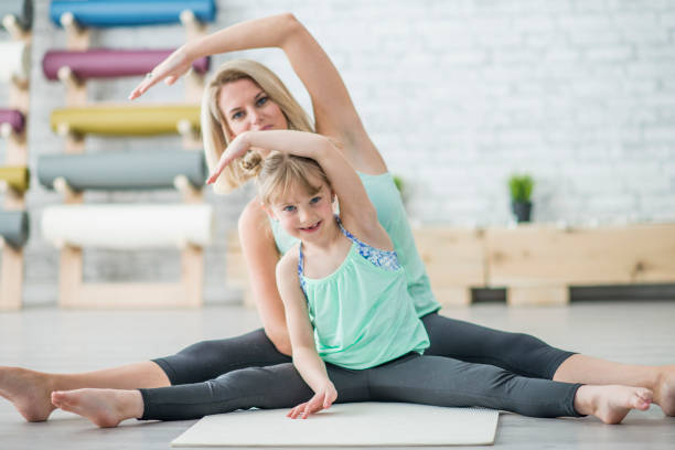 istock Mother and Daughter Stretching 1445217754