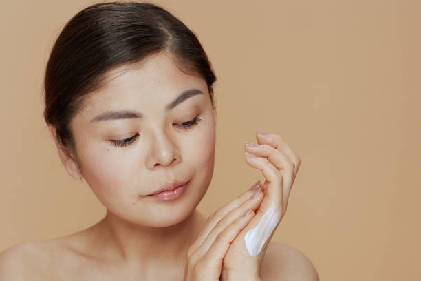 istock modern asian female with hand cream on beige background 1445219863