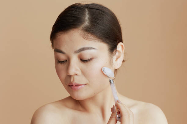 istock relaxed modern asian woman with roller massager 1445219870