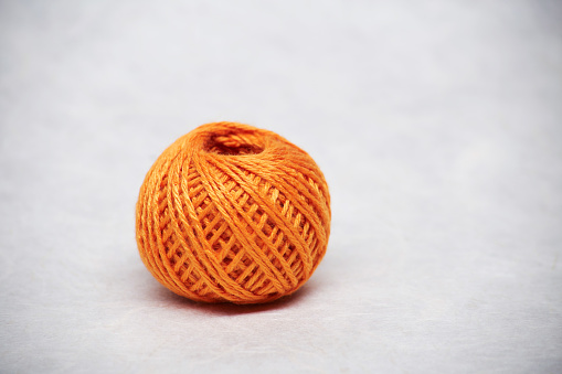 Side view of red & orange cotton yarn spindles.