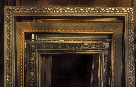 close up of a retail display of a stack of old picture frames leaning against a wall, for sale at a salvage yard, Long Island, New York