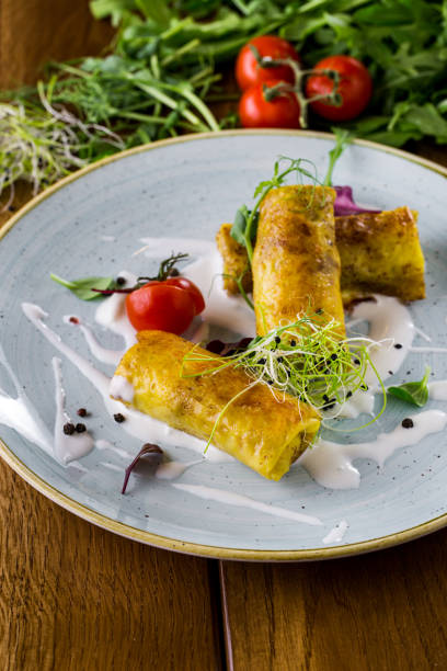 istock Pancakes with meat, on a blue ceramic plate, with sour cream, microgreen, cherry tomatoes and basil leaves. Wooden background with parchment and cottage cheese, cherry tomato branch, arugula and microgreen. 1445221565