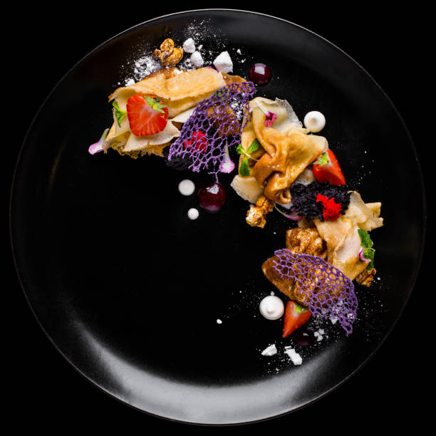 istock Pancakes with maple syrup, strawberries, raspberries and black currant on a white ceramic plate. Black background 1445221588