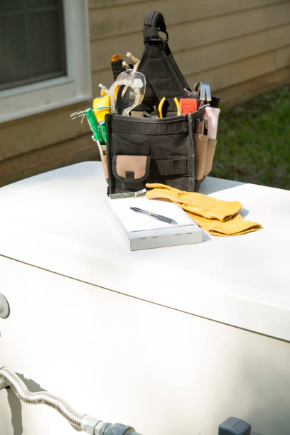 istock Blue collar tools on top of a home generator.   Tool bag with tools, safety gloves and invoice clipboard. 1445222355