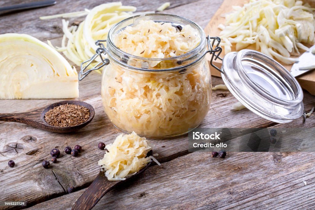 Homemade sauerkraut Homemade sauerkraut with cumin and juniper berries in a glass jar, closeup Appetizer Stock Photo