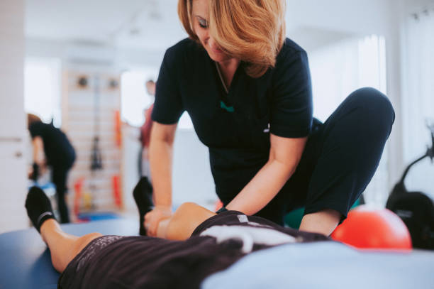 istock Physiotherapist helps a patient to restore movement 1445224511