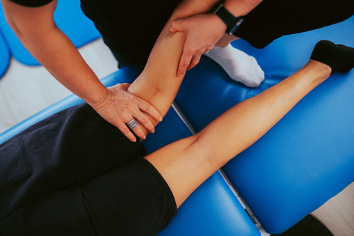 Physiotherapist helps a patient to restore movement