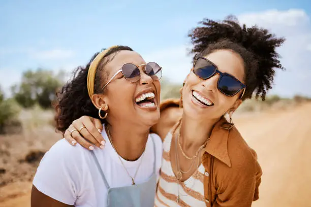 Photo of Girl friends, hug and travel summer vacation outdoors on safari. Diverse happy gen z women friendship, love embrace and support or comic care free together on holiday fun lifestyle activity