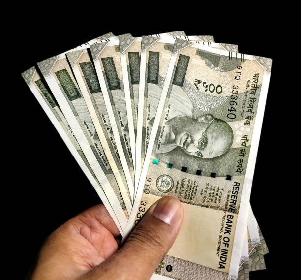 istock Hand holding five hundred Indian rupee notes against white background 1445227440