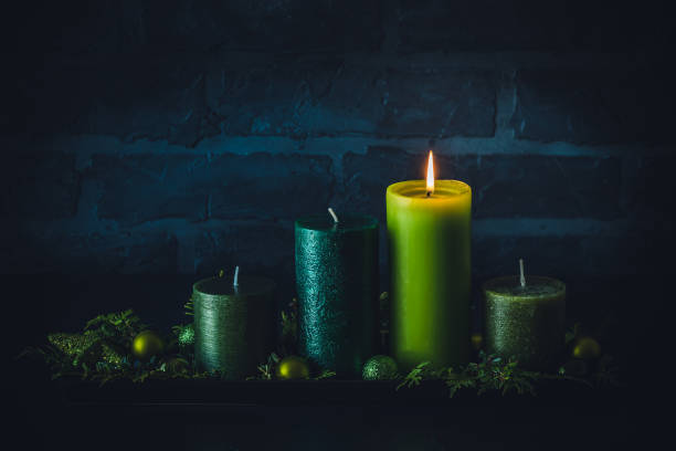 istock Advent wreath with four different candles in green colors on dark background 1445232652