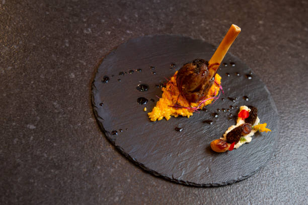 istock Presentation of baked lamb meat on a black background 1445237905