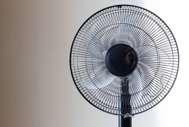 Closeup on electric floor standing fan in the modern living room in sunny hot summer day. Close up of Floor standing fan electric fan stock pictures, royalty-free photos & images