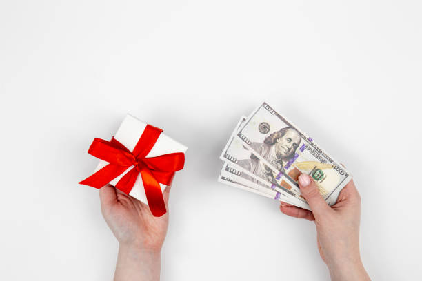 istock Hand with dollars and a gift box on a white background isolated, flat lay. 1445238057