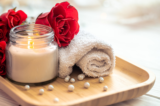 Spa composition with roses and candle on blurred background, valentine's day concept.