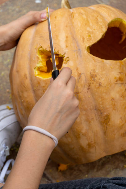istock Carved Halloween pumpkin, jack lantern, with carving tools. Spooky laughing, scary head. 1445240948