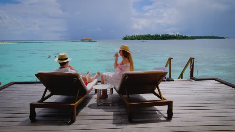 Couple is on a terrace. Man and woman is happy on Maldives.