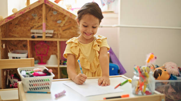 istock Little girl drawing while sitting at the table in her room 1445245019