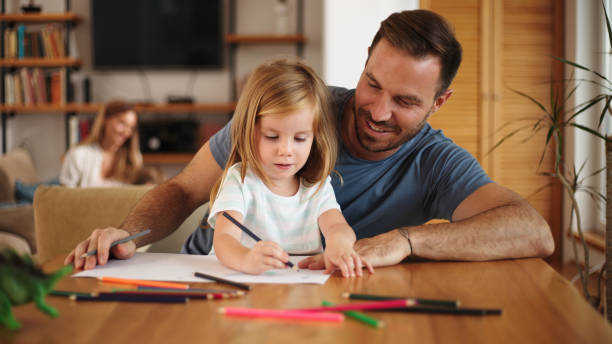 istock Father and daughter having a good time while drawing at home 1445245230