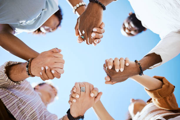 diversity, support and people holding hands in trust and unity for community against sky background. hand of diverse group in solidarity for united team building collaboration and teamwork success - sakinlik stok fotoğraflar ve resimler