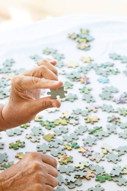 istock Senior Woman is Playing Puzzle. 1445245527