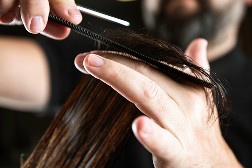 Hair dresser is cutting hair.