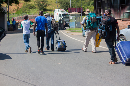 Manica, Mozambique - April 15, 2022: Travelers crossing the Machipanda border from Zimbabwe to Mozambique, carrying their luggage