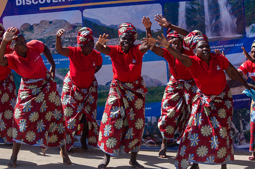 Manica, Mozambique - April 15, 2021: African women dancing wearing traditional wax prints (Ankara clothing)