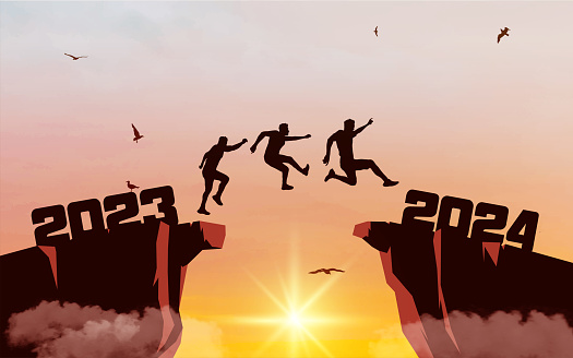Silhouette of men jumping from a cliff over a cliff with sunlight. Sunset sky with clouds and flying birds. Leap concept in 2024.
