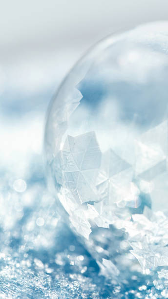 istock frozen bubble with bokeh background. Beautiful frosty patterns on frozen soap bubble 1445255312