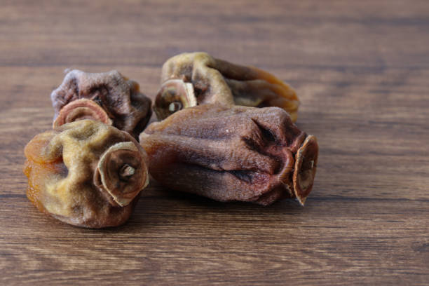 istock Dried persimmon on a plate on wooden table. 1445260204