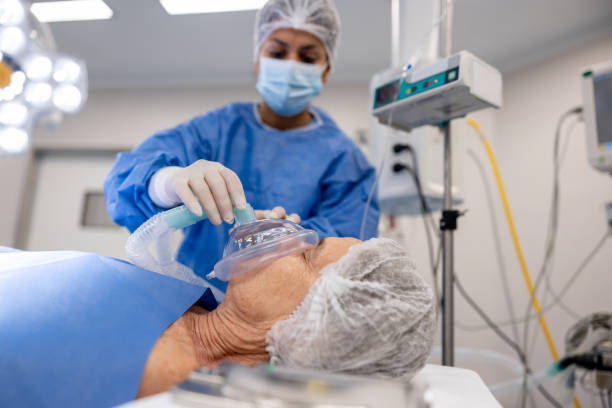 médico colocando una máscara de oxígeno en un paciente bajo anestesia en el hospital - anestesista fotografías e imágenes de stock