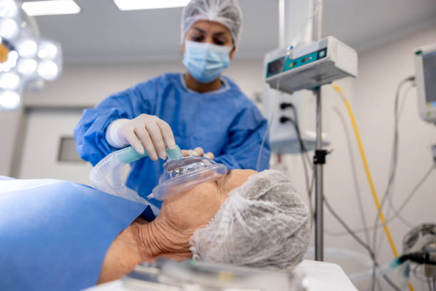 un médecin met un masque à oxygène sur un patient sous anesthésie à l’hôpital - human cardiopulmonary system photos et images de collection