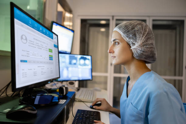 Radiologist in the control room performing a medical scan Radiologist in the control room performing a medical scan and looking at the computer monitor -healthcare and medicine concepts healthcare technology stock pictures, royalty-free photos & images