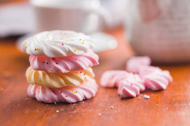 sigh or homemade meringue is a sweet made from egg whites, sugar and lemon on the rustic kitchen wooden table. Selective Focus