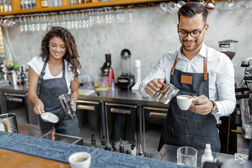 Barista preparing cup of coffee, espresso with latte or cappuccino for customer order in coffee shop, bartender pouring milk, Small business owner and startup in coffee shop and restaurant concept