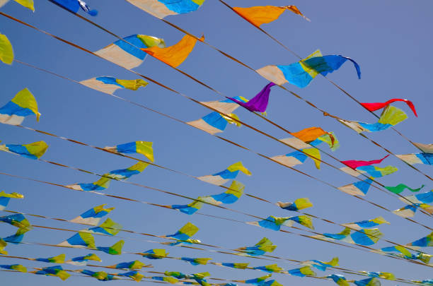 istock Multicolored triangular small flags to celebration party against blue sky.Street holiday concept with space for text. 1445263988