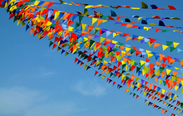 istock Multicolored triangular small flags to celebration party against blue sky.Street holiday concept with space for text. 1445264292
