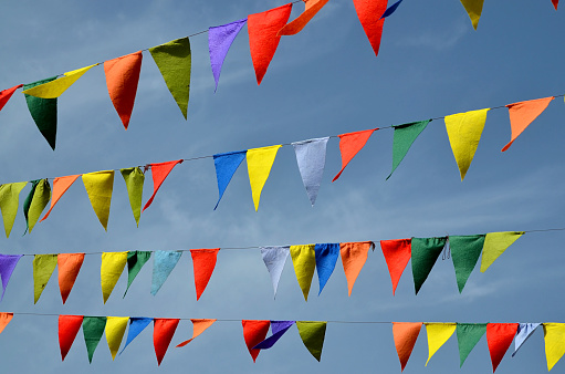 Multicolored triangular small flags to celebration party against blue sky.Street holiday concept with space for text.Selective focus.