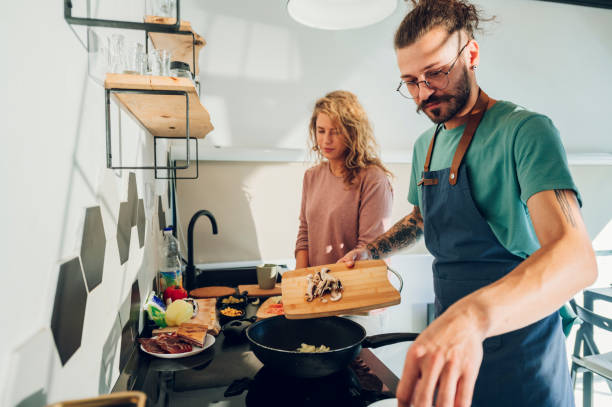 istock Young couple making breakfast together in the kitchen at home 1445264675