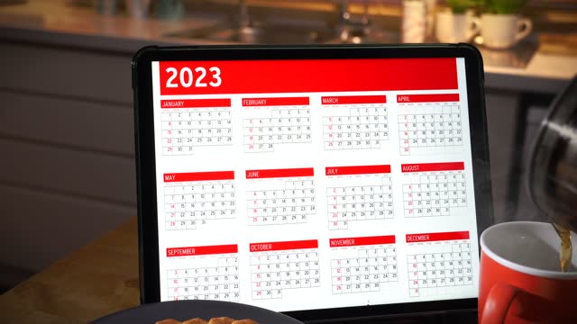 Tablet computer with 2023 november calendar on screen above kitchen table.