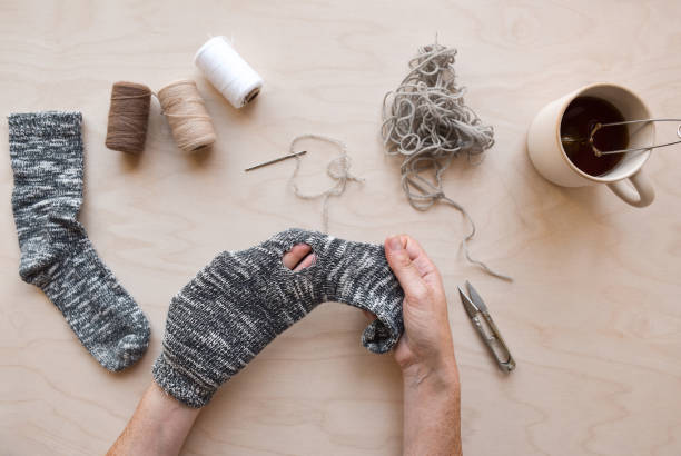 istock Woman's hands holding sock with a hole to be fixed 1445271577
